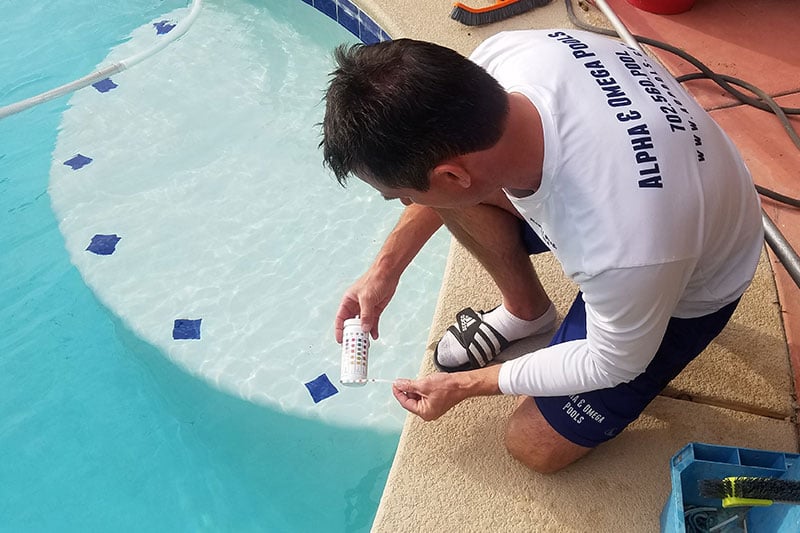 Mickey Blake of Alpha & Omega Pool Services testing pool chemical balance